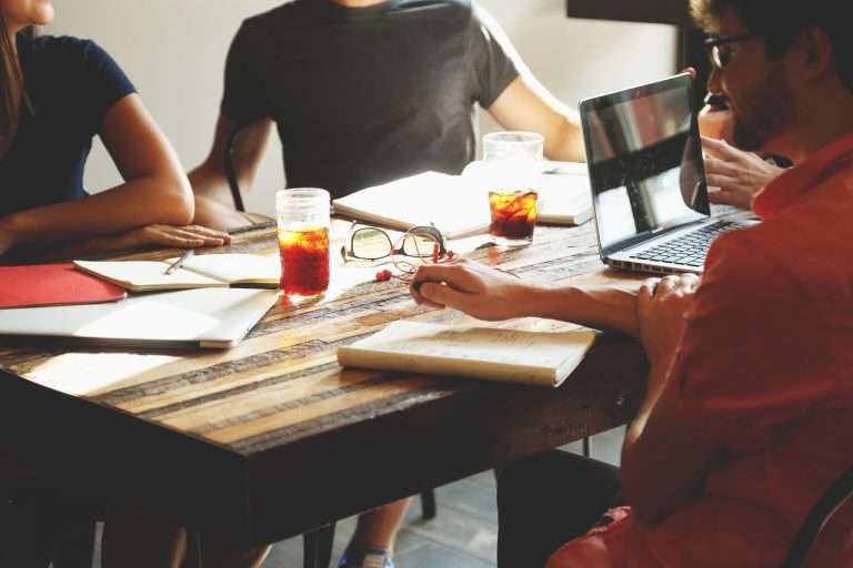 people sitting at table together with laptop