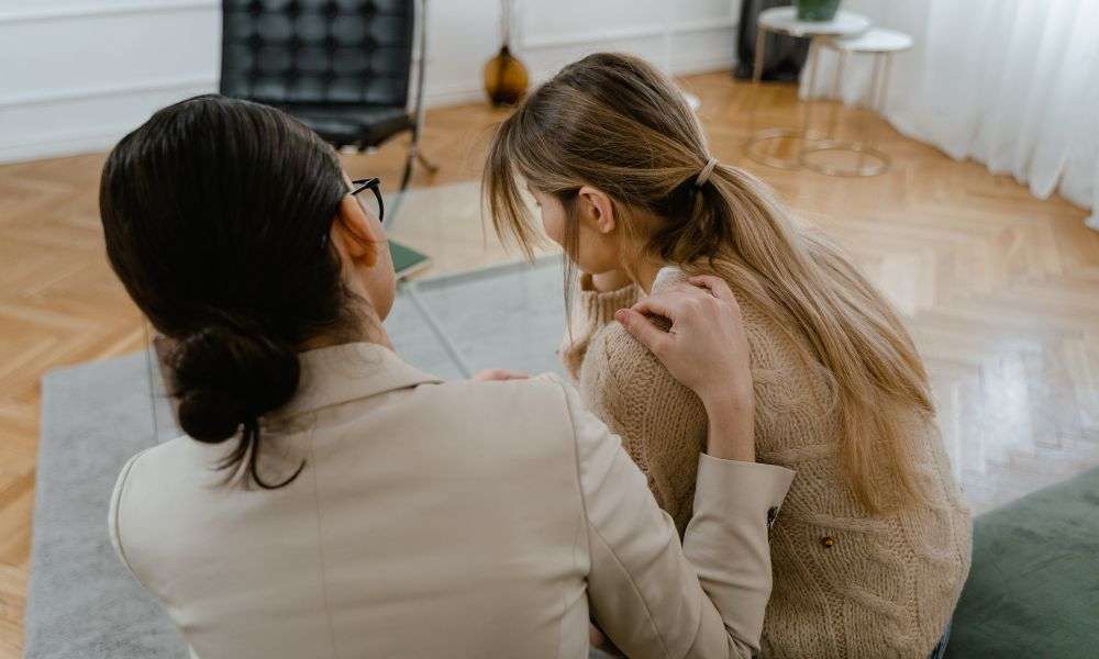 woman comforting another woman
